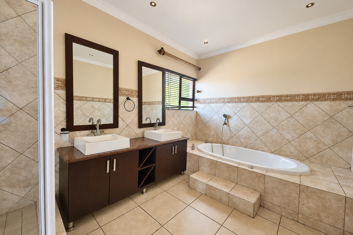 Spacious bathroom featuring a double vanity with vessel sinks, a built-in bathtub with tiled surround, and a separate shower enclosure.