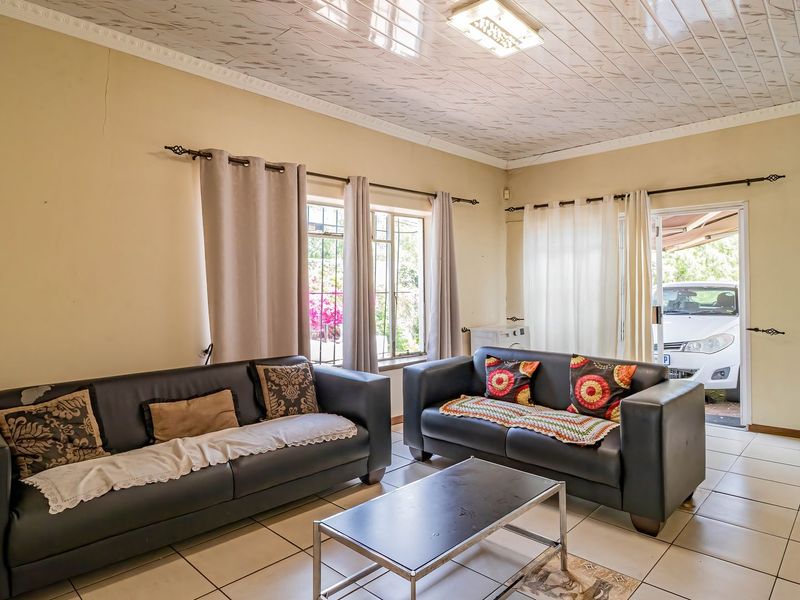 Living room featuring tiled flooring, plastic ceiling panels, and direct access to the exterior through a glass sliding door.