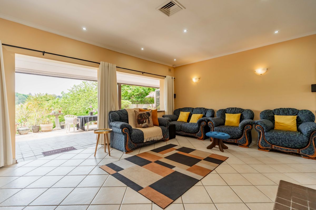 Spacious living room featuring tiled flooring, recessed lighting, and large sliding glass doors that provide seamless access to the outdoor patio area.