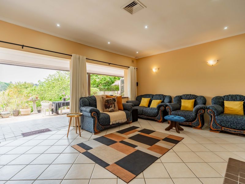 Spacious living room featuring tiled flooring, recessed lighting, and large sliding glass doors that provide seamless access to the outdoor patio area.