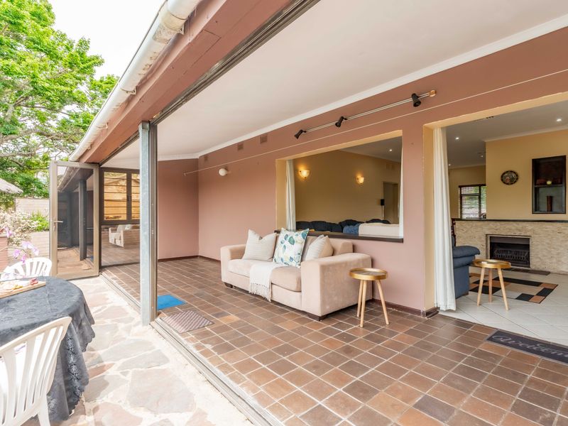 A covered patio area featuring tiled flooring and large sliding glass doors that provide seamless access to the interior living space with a fireplace.