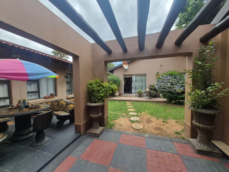 Covered patio area featuring a timber pergola, paved flooring, and direct access to the rear garden and main dwelling.