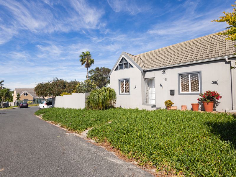 Front elevation of a single-story residential house featuring a tiled roof, security bars on windows, and a well-maintained front garden area.