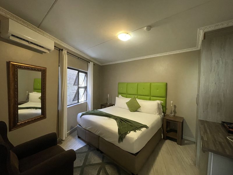 A well-maintained bedroom featuring crown molding, an integrated air conditioning unit, and built-in wardrobe storage.