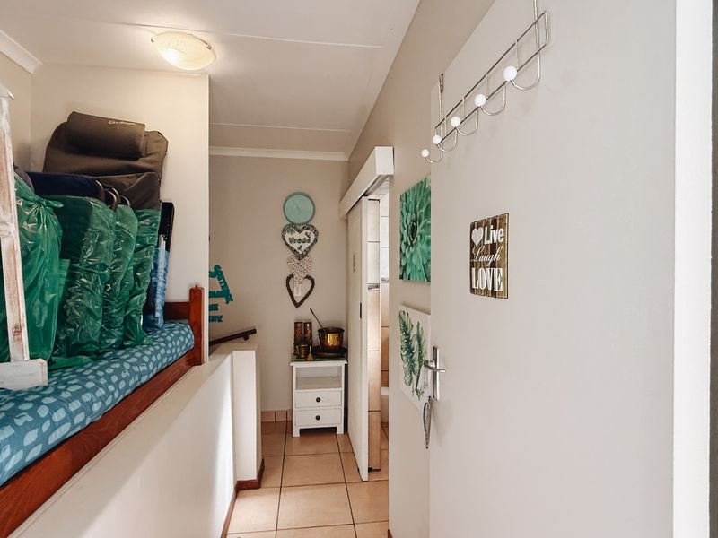 A functional hallway featuring tiled flooring and a sliding door, providing access to adjacent rooms within the townhouse.