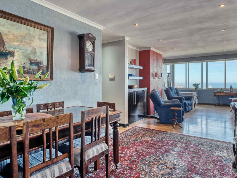 Spacious open-plan living and dining area featuring hardwood flooring, recessed lighting, and large windows offering expansive views.