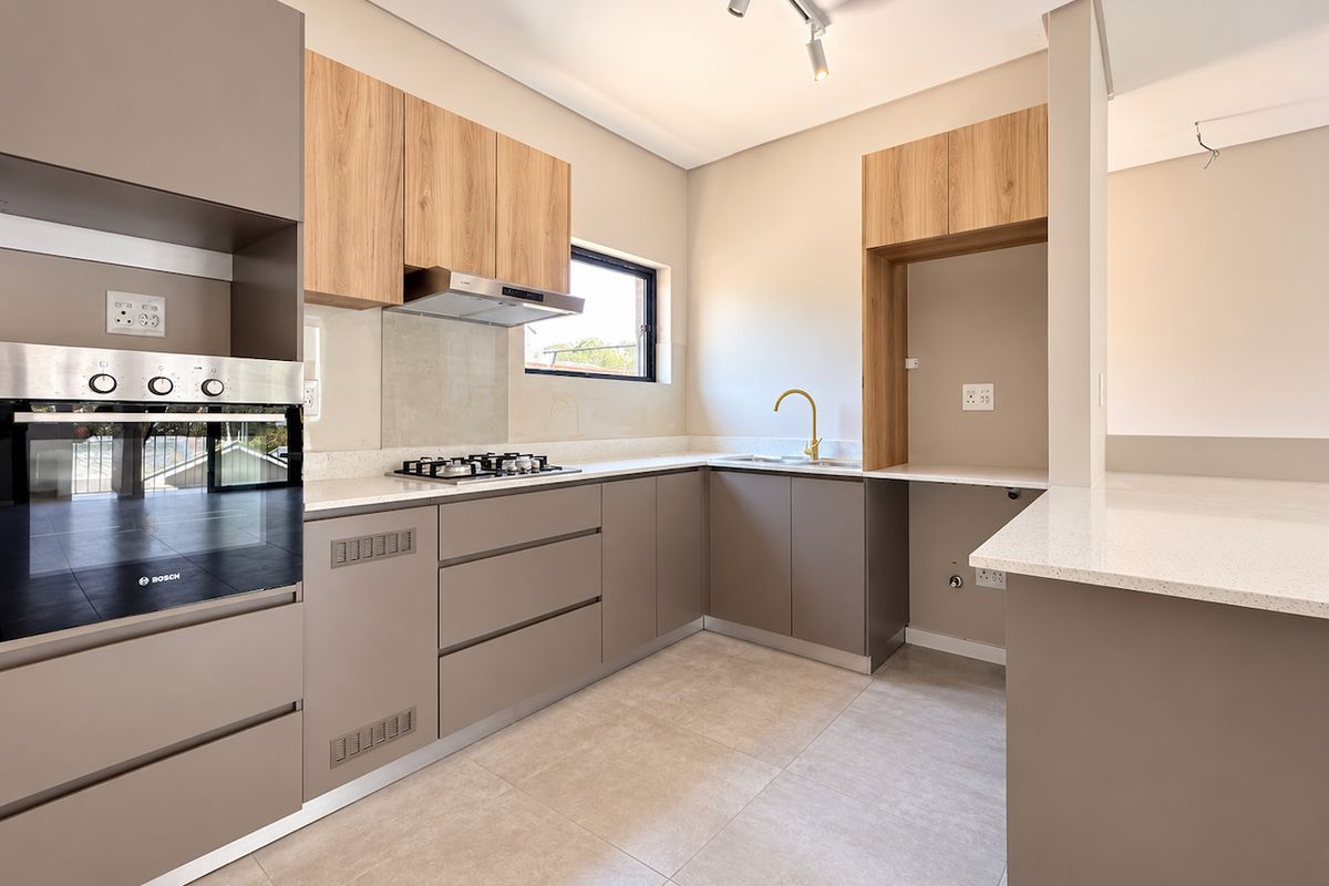 Modern kitchen featuring sleek cabinetry, quartz countertops, built-in oven, gas hob, and high-quality finishes in a clean, contemporary design.