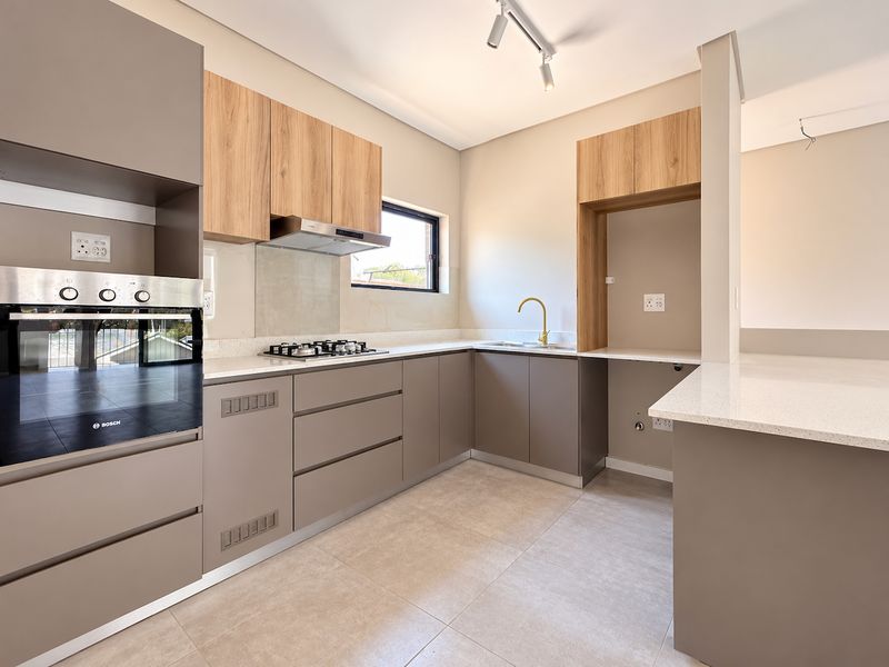 Modern kitchen featuring sleek cabinetry, quartz countertops, built-in oven, gas hob, and high-quality finishes in a clean, contemporary design.