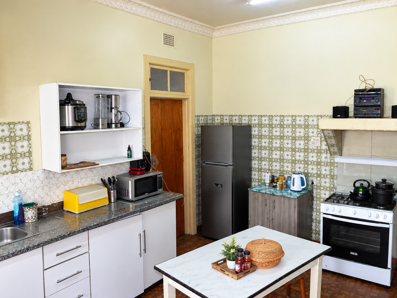 A functional kitchen featuring laminate countertops, a gas stove with extractor hood, double bowl sink, and classic decorative ceiling cornicing.