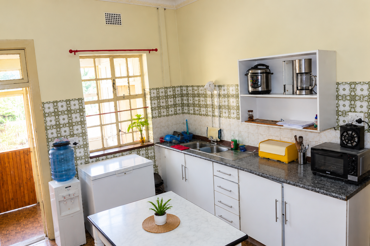 A functional kitchen featuring white cabinetry, laminate countertops, a double sink, and decorative tiled backsplash with direct access to an exterior door.