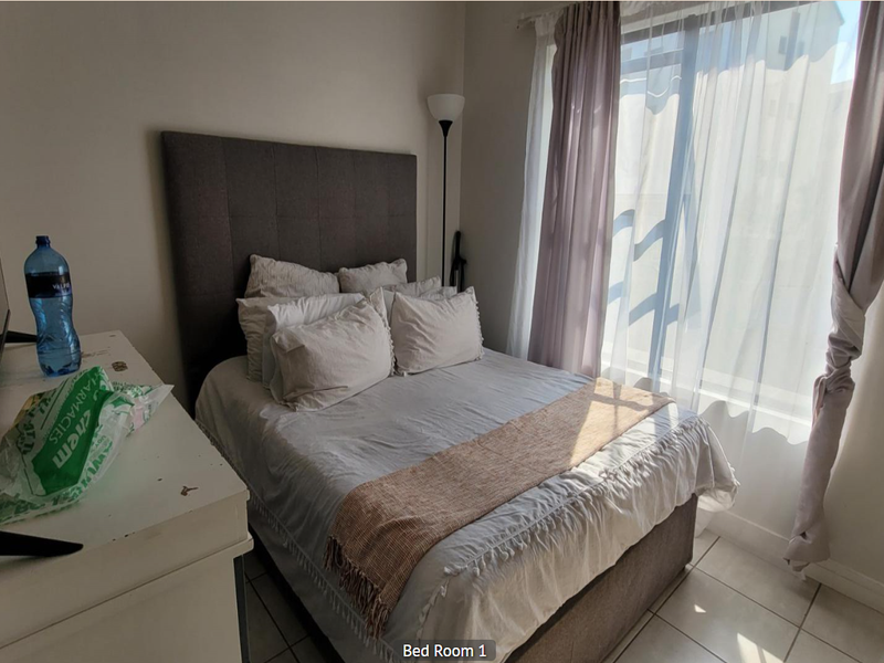 A bedroom featuring tiled flooring and a sliding door providing natural light.