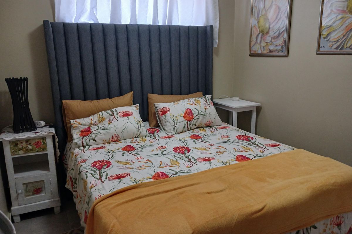 A cozy bedroom featuring tiled flooring and a neutral wall finish, providing a comfortable and functional sleeping space.