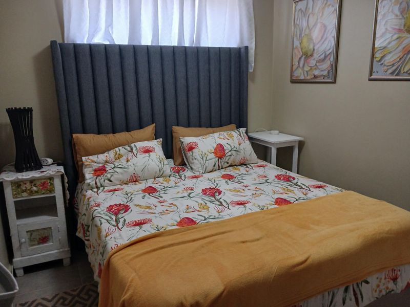 A cozy bedroom featuring tiled flooring and a neutral wall finish, providing a comfortable and functional sleeping space.