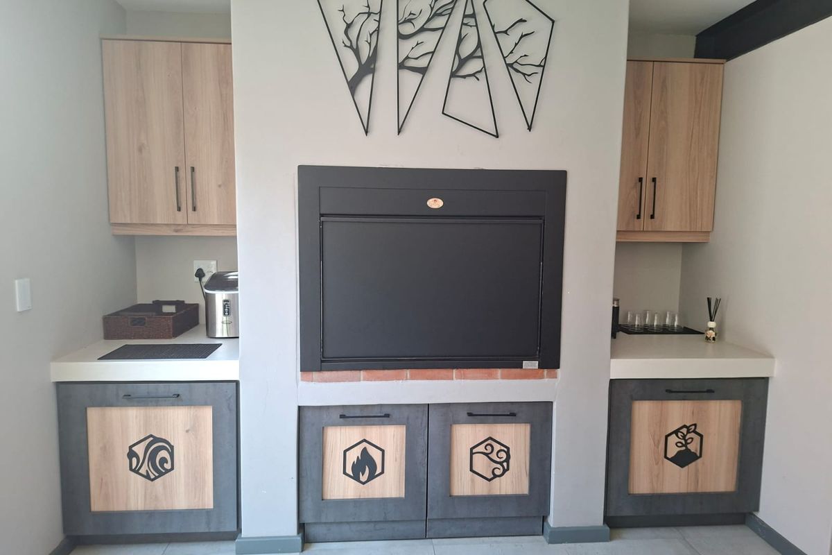 A modern living area featuring a central built-in fireplace flanked by custom cabinetry with integrated storage and stone countertops.
