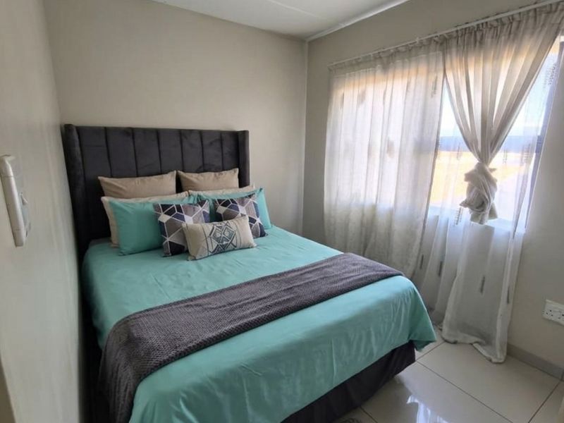 A well-maintained bedroom featuring neutral wall tones, polished tile flooring, and recessed ceiling lighting, providing a clean and functional living space.