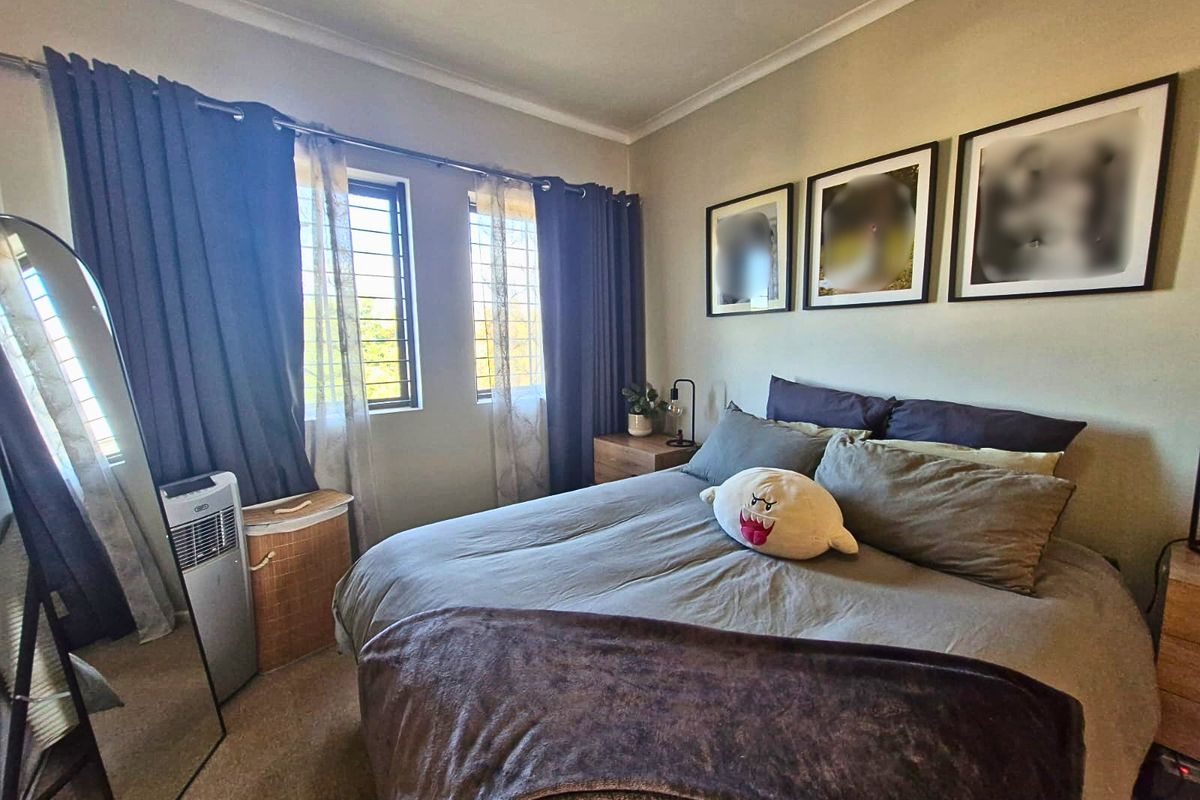 A comfortable bedroom featuring security bars on the windows and decorative cove cornicing, providing a functional and secure living space.