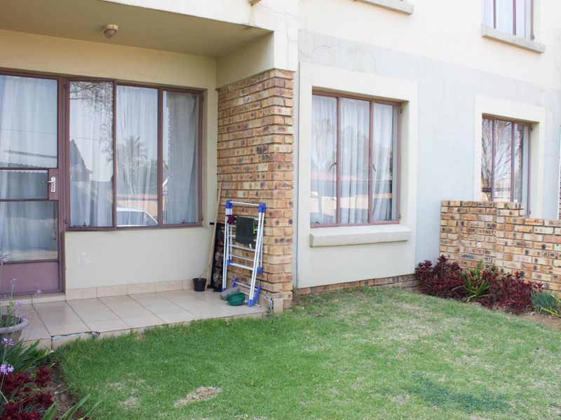 A ground floor patio area featuring tiled flooring, face brick accents, and direct access to a small private garden space.
