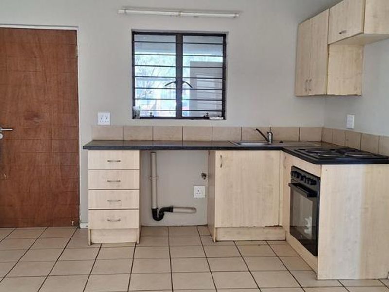 A functional kitchen featuring built-in cabinetry, a built-in oven with hob, tiled flooring, and a tiled backsplash, offering a practical layout for renovation.