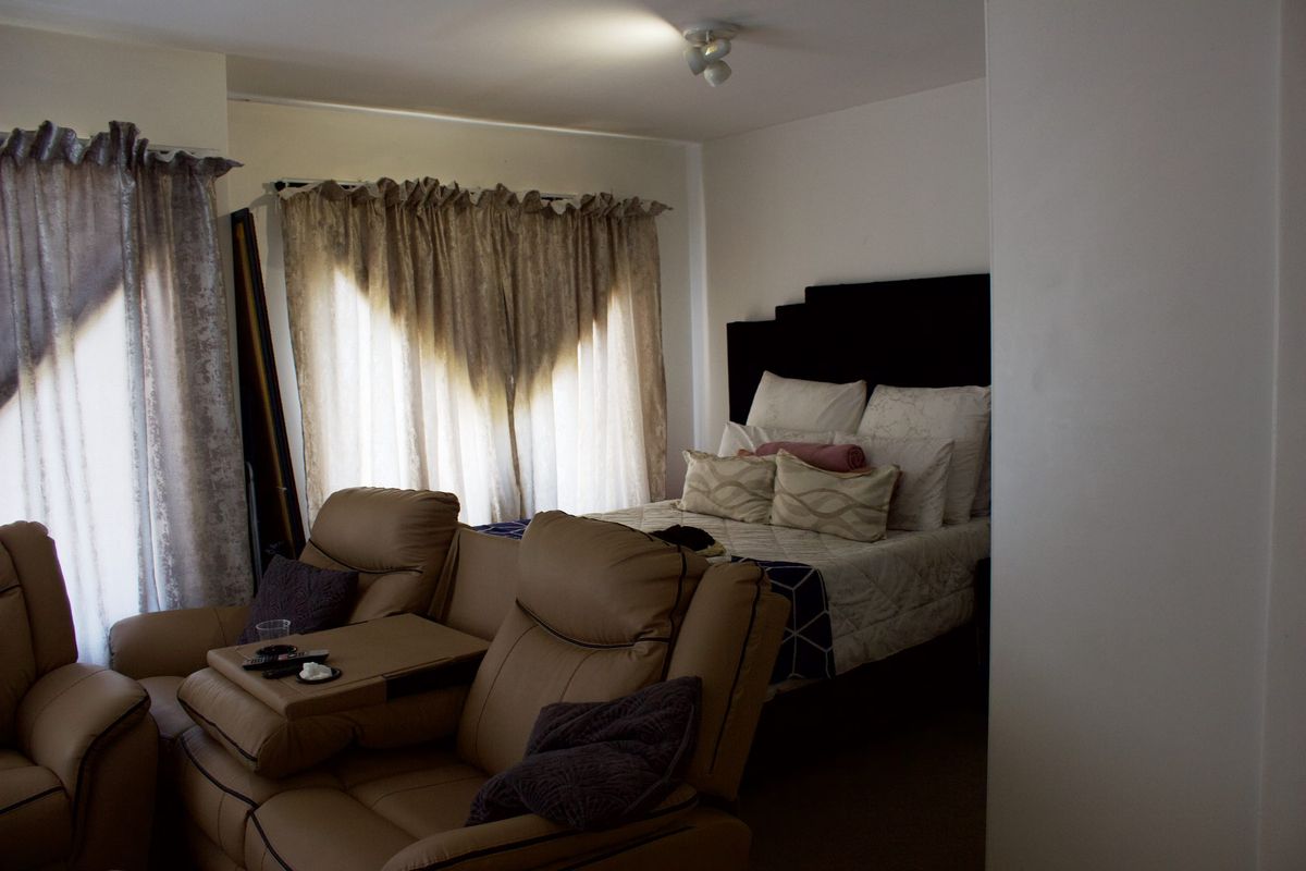 A bedroom featuring neutral wall finishes and natural light through window treatments.
