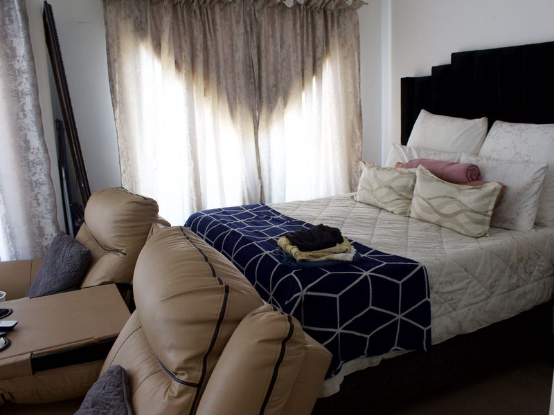A bedroom featuring a window with installed curtain tracks, providing natural light to the space.