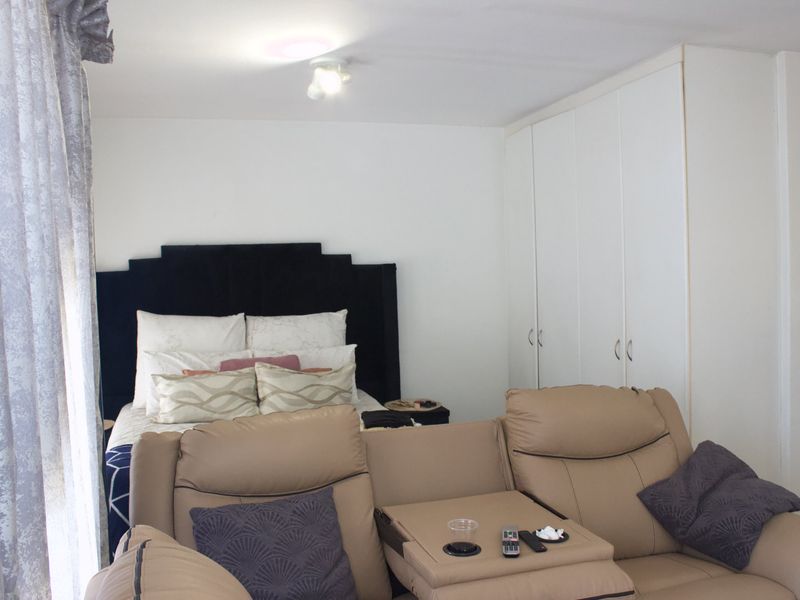 A bedroom featuring built-in cupboards and a ceiling light fixture, providing functional storage and lighting within the space.