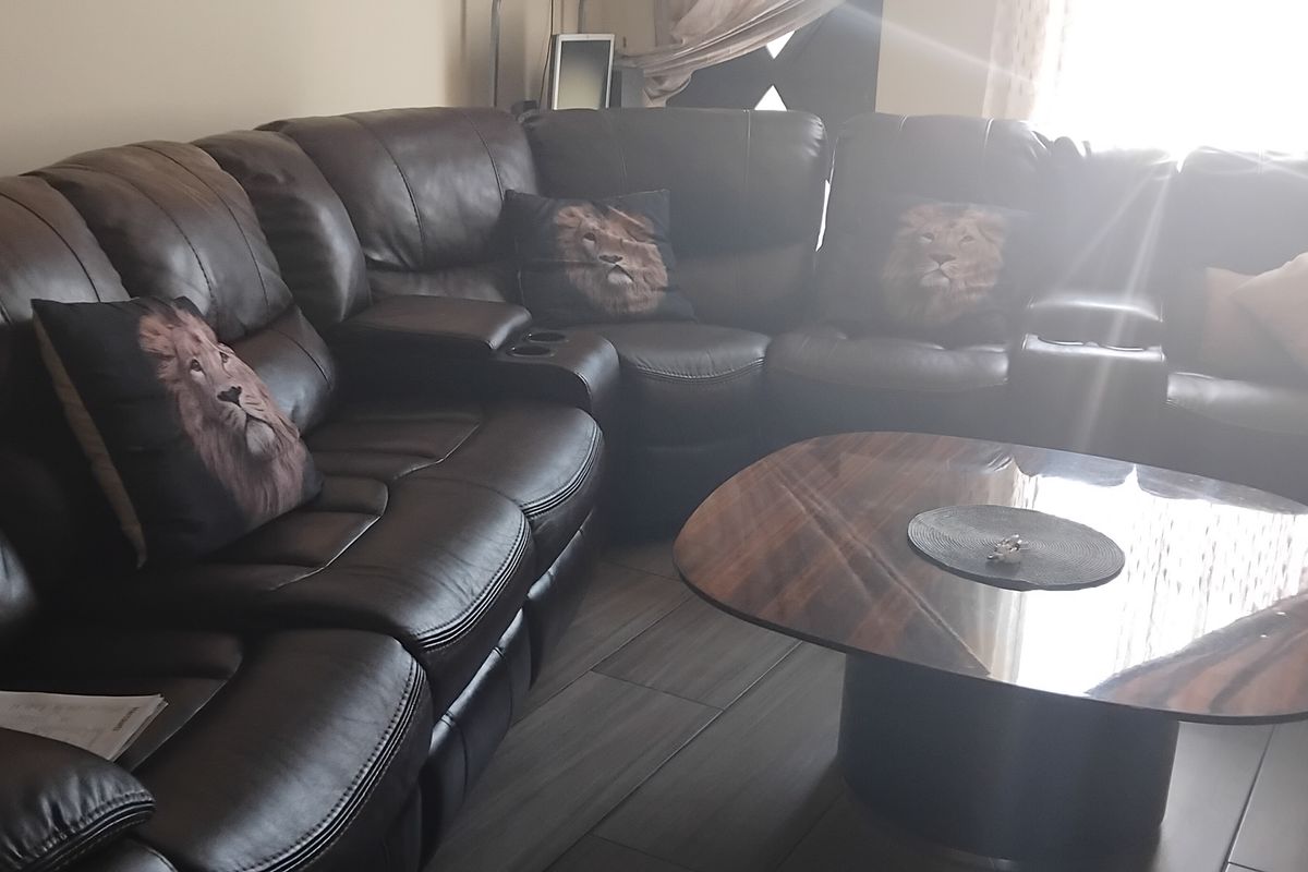 A living room area featuring tiled flooring and natural light from a window.
