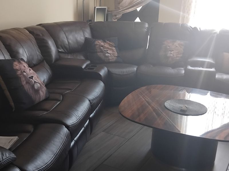A living room area featuring tiled flooring and natural light from a window.