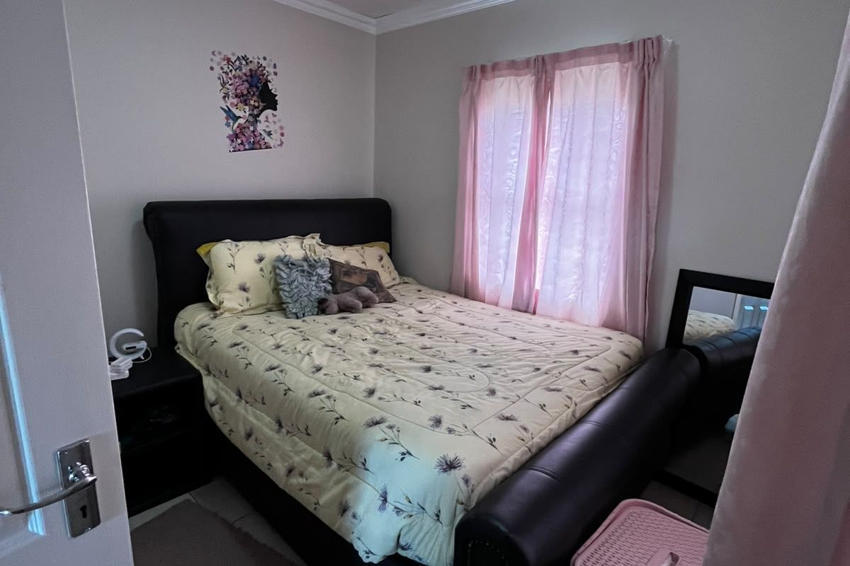 A compact bedroom featuring tiled flooring, ceiling cornice detailing, and a central flush mount light fixture.