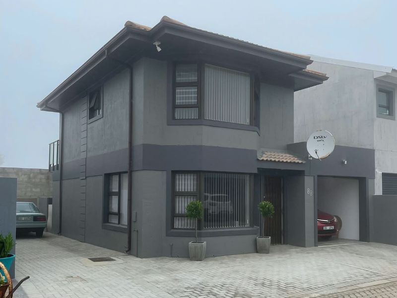 A modern two-story residential property featuring a grey exterior finish, paved driveway, and an integrated single garage.