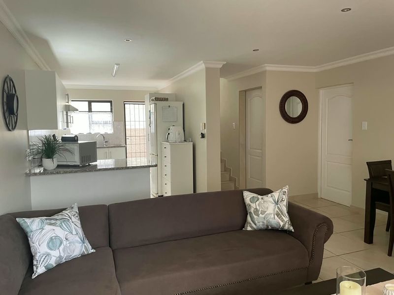 Open-plan living area featuring a kitchen with granite countertops and tiled flooring, seamlessly connected to the main living space.