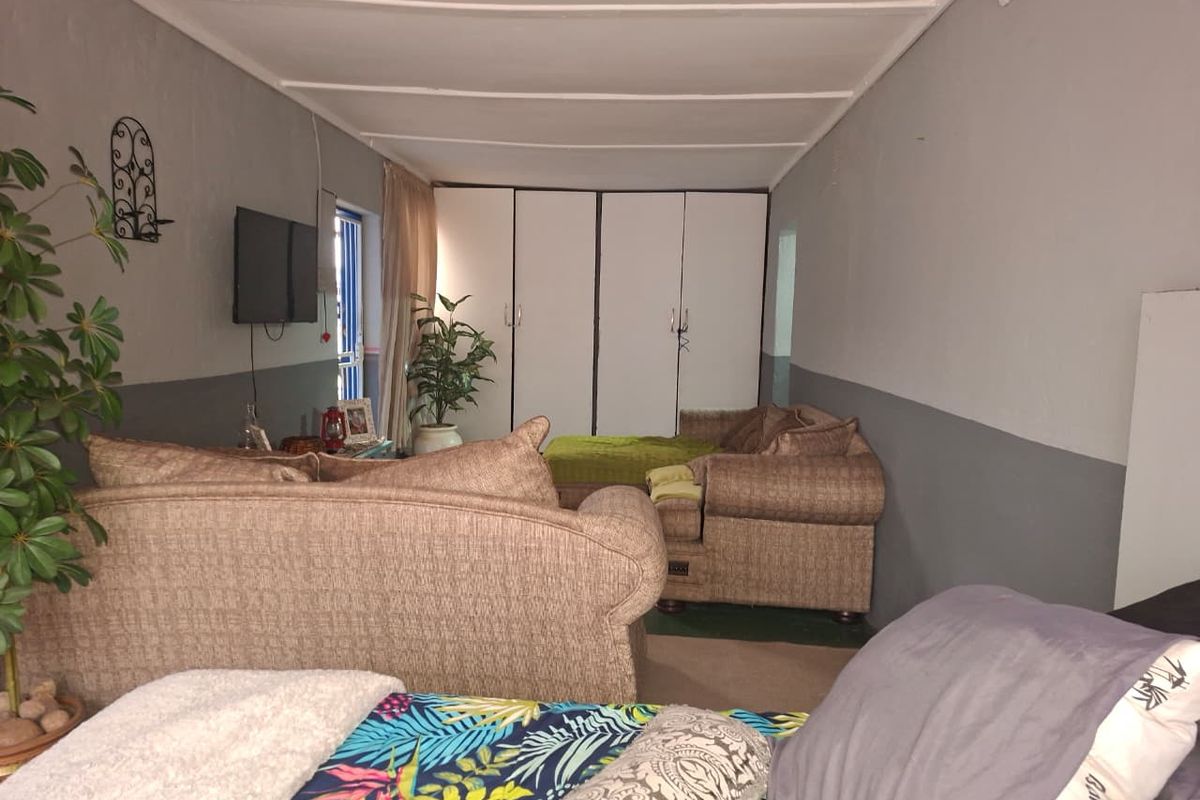 A bedroom featuring built-in cupboards and a simple interior layout with two-tone wall paint.