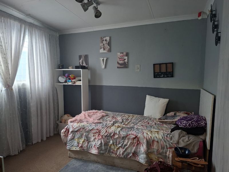 A bedroom featuring carpeted flooring and a ceiling-mounted spotlight, requiring some cosmetic attention to the walls and ceiling.
