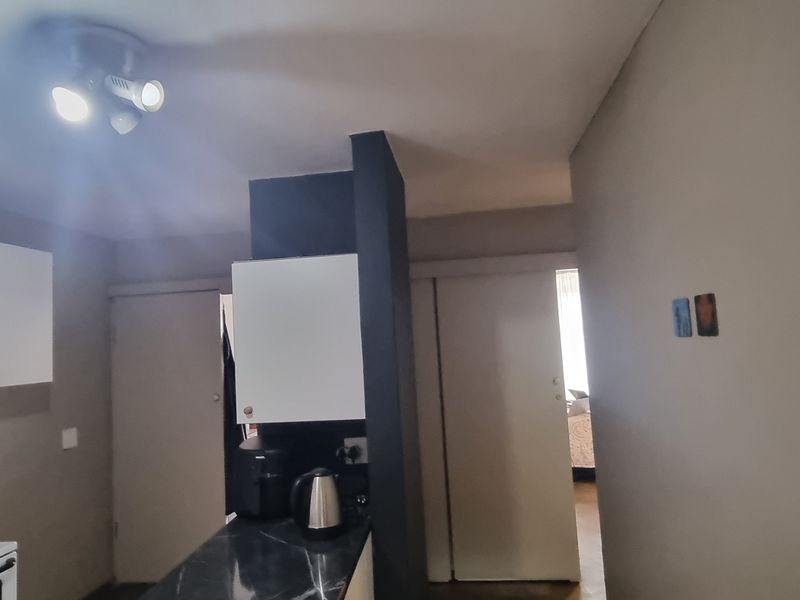 A functional kitchen area featuring built-in cabinetry, a countertop, and an electric stove, providing a practical space for meal preparation.