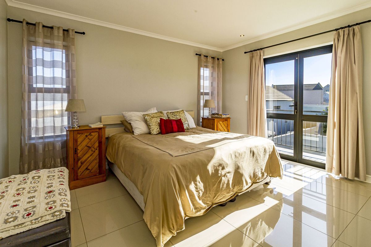 Bright and spacious bedroom featuring polished tiled flooring, recessed lighting, and direct access to a private balcony through large glass sliding doors.