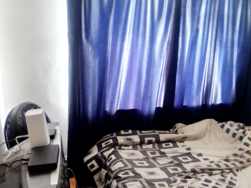 A bedroom featuring a window with blue curtains, providing natural light and privacy.