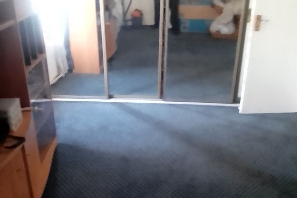Bedroom featuring large mirrored sliding wardrobe doors and fitted carpeting.