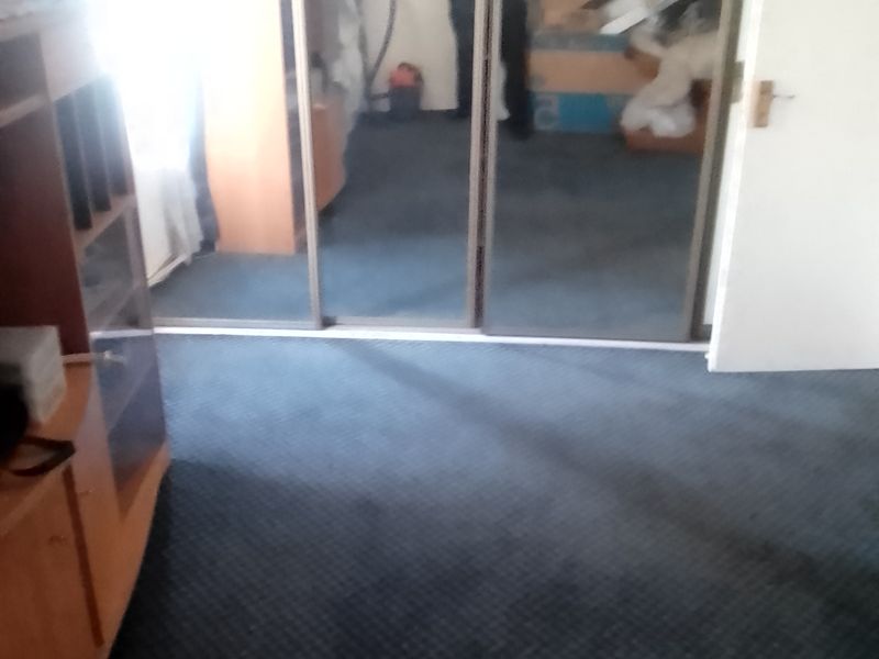 Bedroom featuring large mirrored sliding wardrobe doors and fitted carpeting.