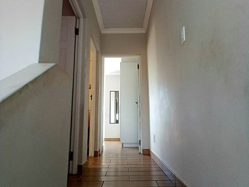 A functional hallway featuring tiled flooring and neutral wall finishes, providing access to multiple rooms within the home.