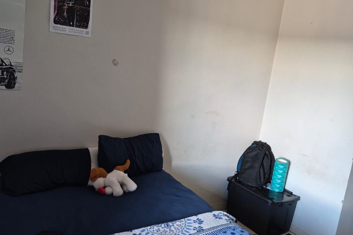 A bedroom featuring tiled flooring and coved ceiling details, currently requiring minor cosmetic wall repairs and fresh paint to enhance the space.