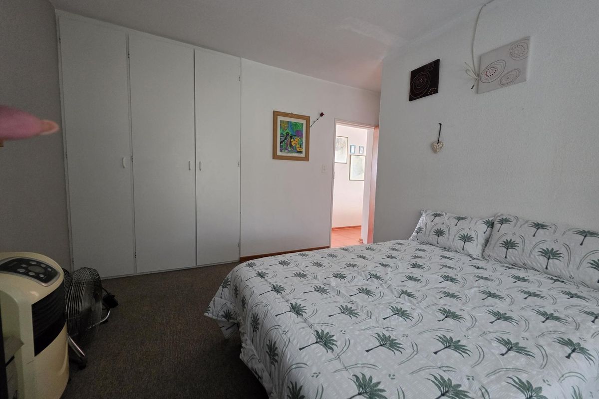 A bedroom featuring built-in cupboards and carpeted flooring.