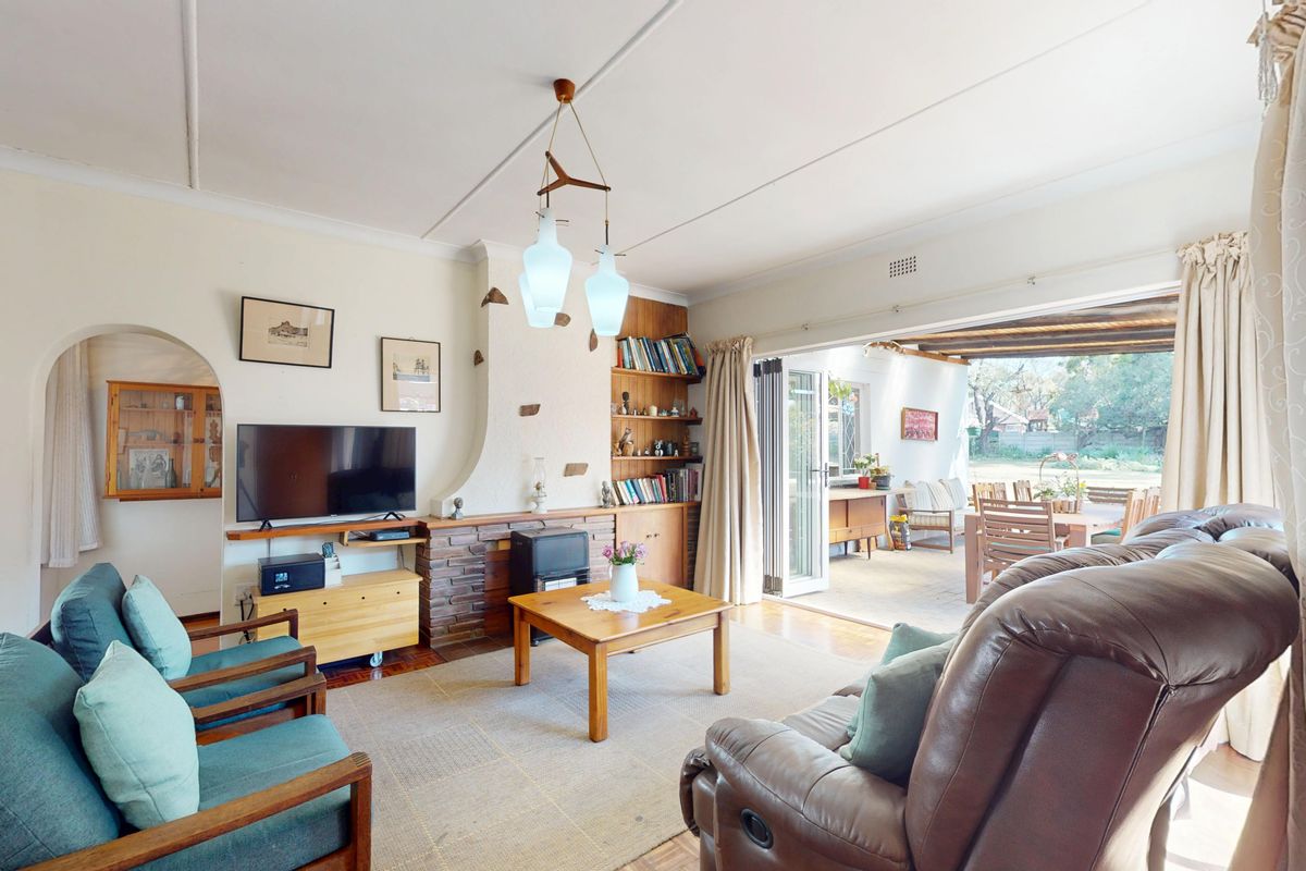 Spacious living room featuring a brick fireplace, built-in shelving, and large sliding glass doors that open onto a covered patio area.