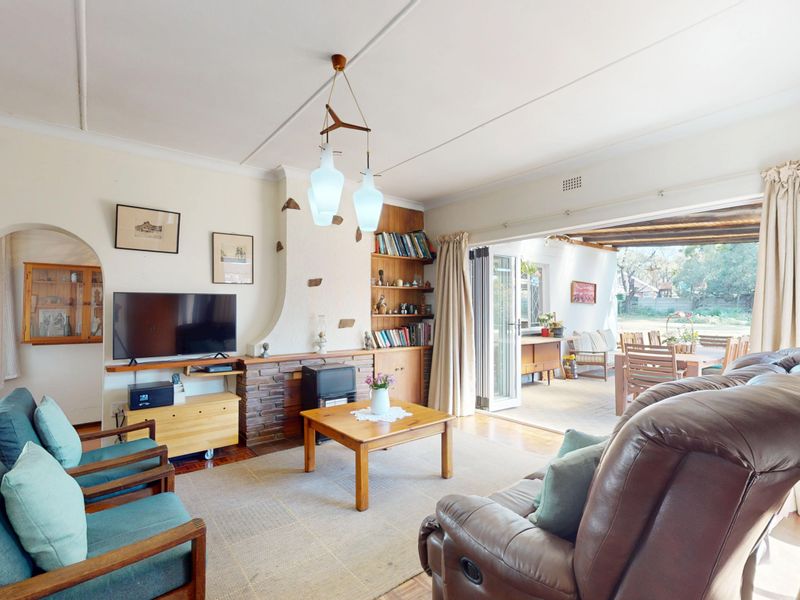 Spacious living room featuring a brick fireplace, built-in shelving, and large sliding glass doors that open onto a covered patio area.