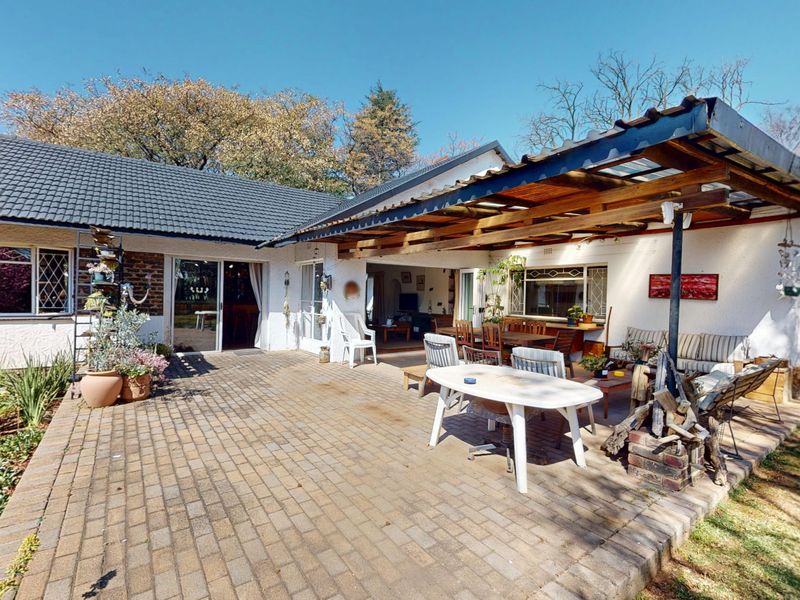 Spacious paved outdoor patio area featuring a timber pergola, providing a functional space for outdoor entertaining and relaxation.