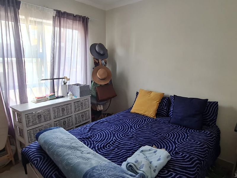 A standard bedroom featuring a window with curtains and decorative coving.