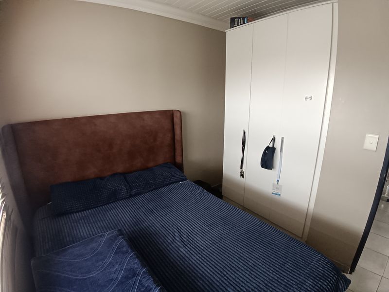 A bedroom featuring a built-in wardrobe and a tongue and groove ceiling finish.