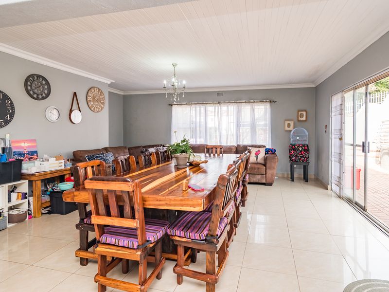Spacious dining area featuring tiled flooring, a tongue and groove ceiling, and large sliding glass doors providing access to the outdoor area.