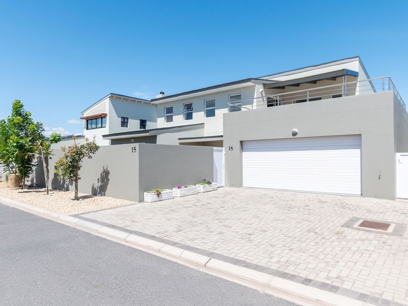 Modern double-storey residential property featuring a paved driveway, secure double garage, and an upper-level balcony with contemporary architectural finishes.