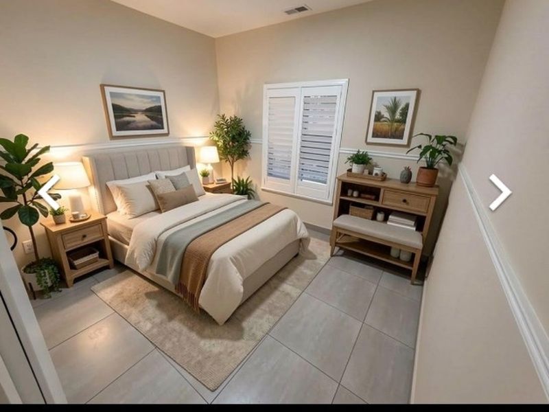 A well-maintained bedroom featuring neutral tiled flooring, plantation shutters, and classic chair rail molding, creating a bright and inviting living space.