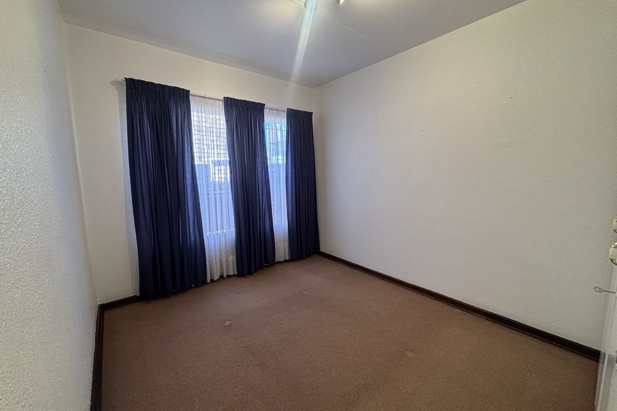 An empty bedroom featuring carpet flooring and neutral walls, offering a blank canvas for personalization and renovation.