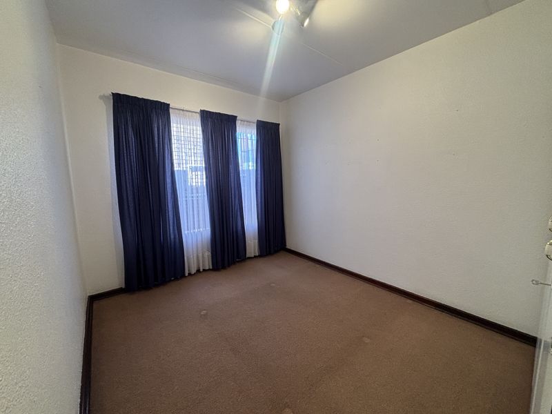 An empty bedroom featuring carpet flooring and neutral walls, offering a blank canvas for personalization and renovation.